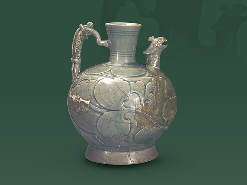 五代—北宋．耀州窯剔劃花鳳首執(zhí)壺+釉色青綠泛藍(lán)，腹壁深刻淺浮雕花卉的輪廓，內(nèi)部淺刻葉脈紋理，立體感頗為突出。（圖一）+圖片來(lái)源：《中國(guó)出土瓷器全集15陜西》，頁(yè)114，圖114。